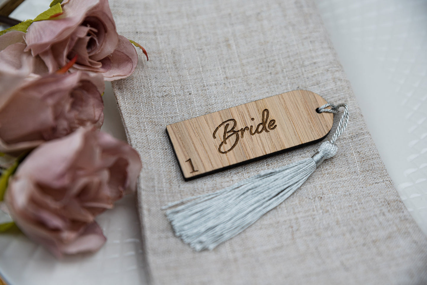 Custom engraved Oak place cards with tassels, adding a touch of elegance to any table setting. Personalised with guest&#39;s names, these unique wedding favors double as stylish table decor and guest seating assignments