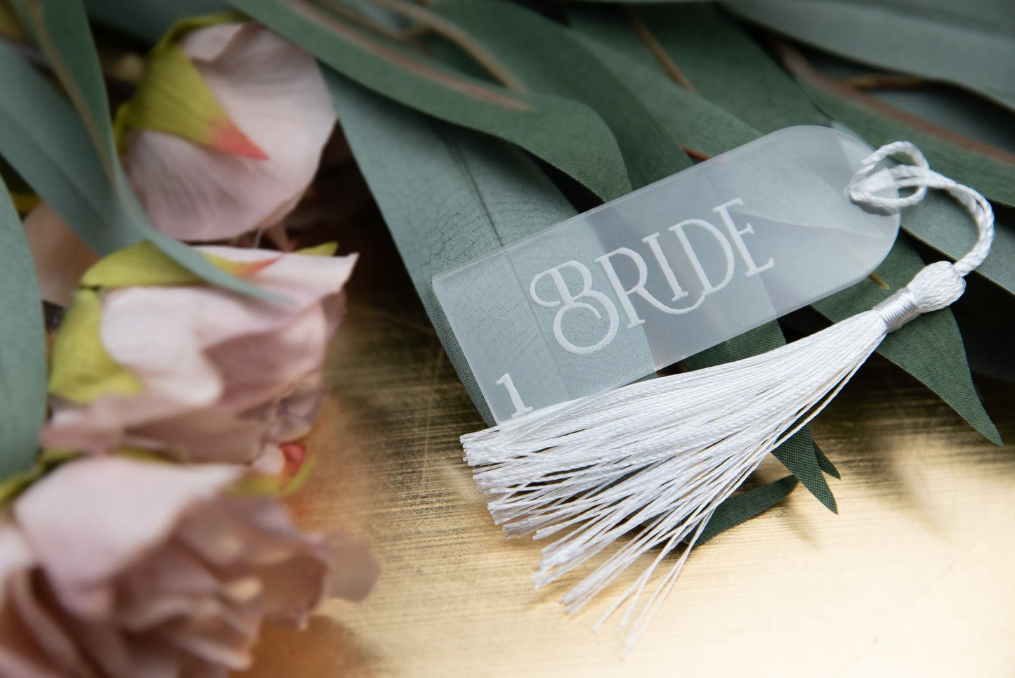 Custom engraved frost acrylic place cards with tassels, adding a touch of elegance to any table setting. Personalised with guest&#39;s names, these unique wedding favors double as stylish table decor and guest seating assignments