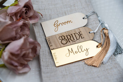 Custom engraved gold mirrored place cards with tassels, adding a touch of elegance to any table setting. Personalised with guest&#39;s names, these unique wedding favors double as stylish table decor and guest seating assignments