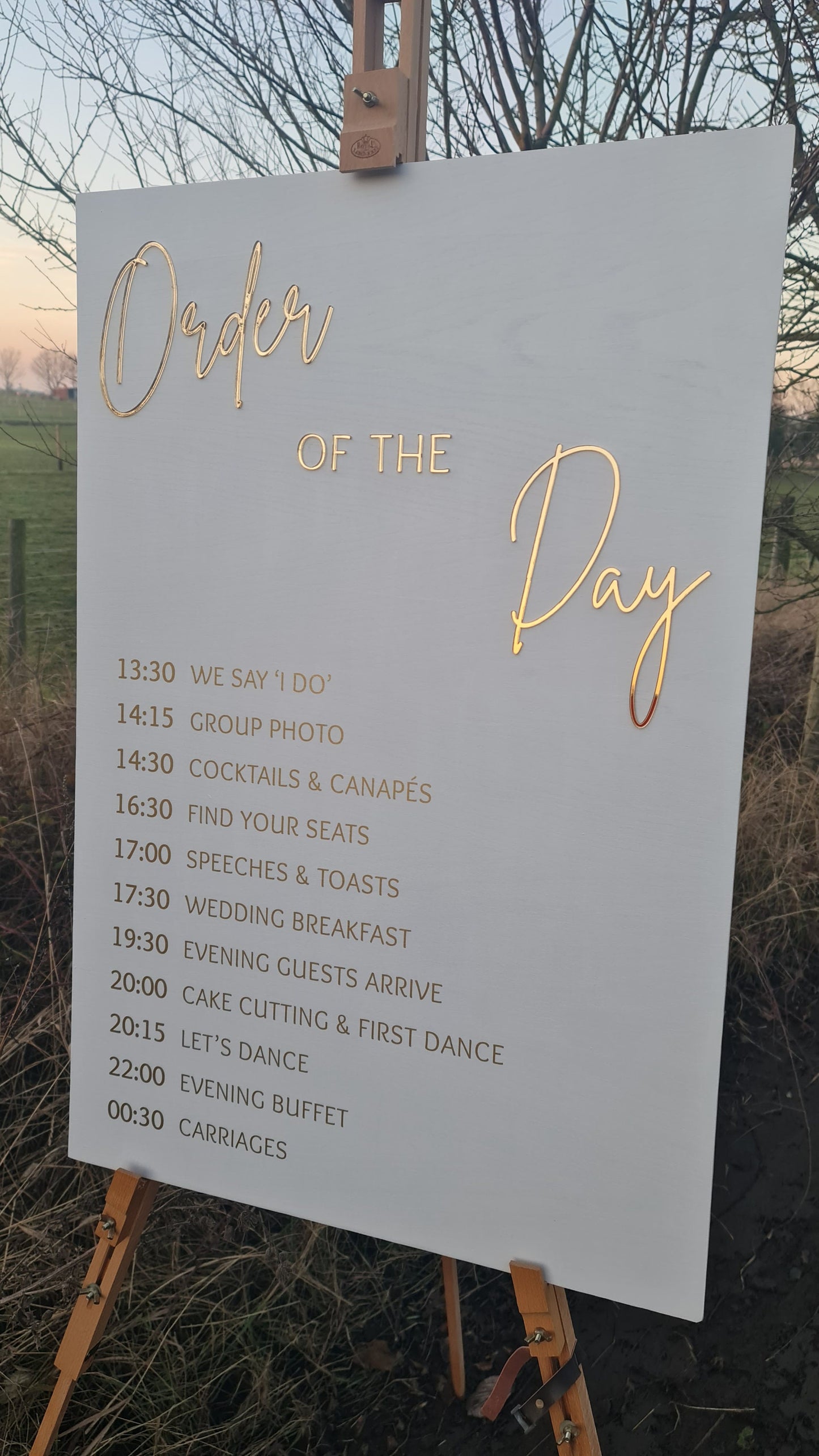 Elegant white and gold order of the day wedding sign with a clear and organized schedule of events, including ceremony and reception, hand-painted with high-quality materials and laser-engraved for a lasting keepsake. Perfect for guiding guests.